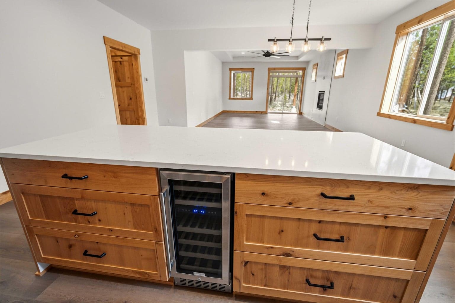 Oversized quartz island with abundant drawer storage and beverage fridge adds style, convenience, and everyday functionality.