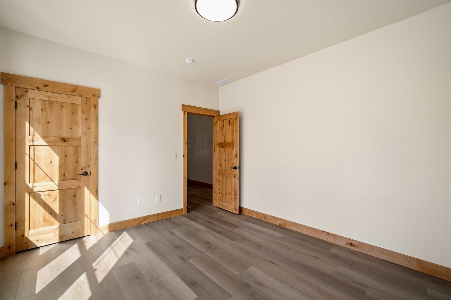 Flexible front office or bedroom with beautiful wood doors, natural light, and easy access to the main living areas.