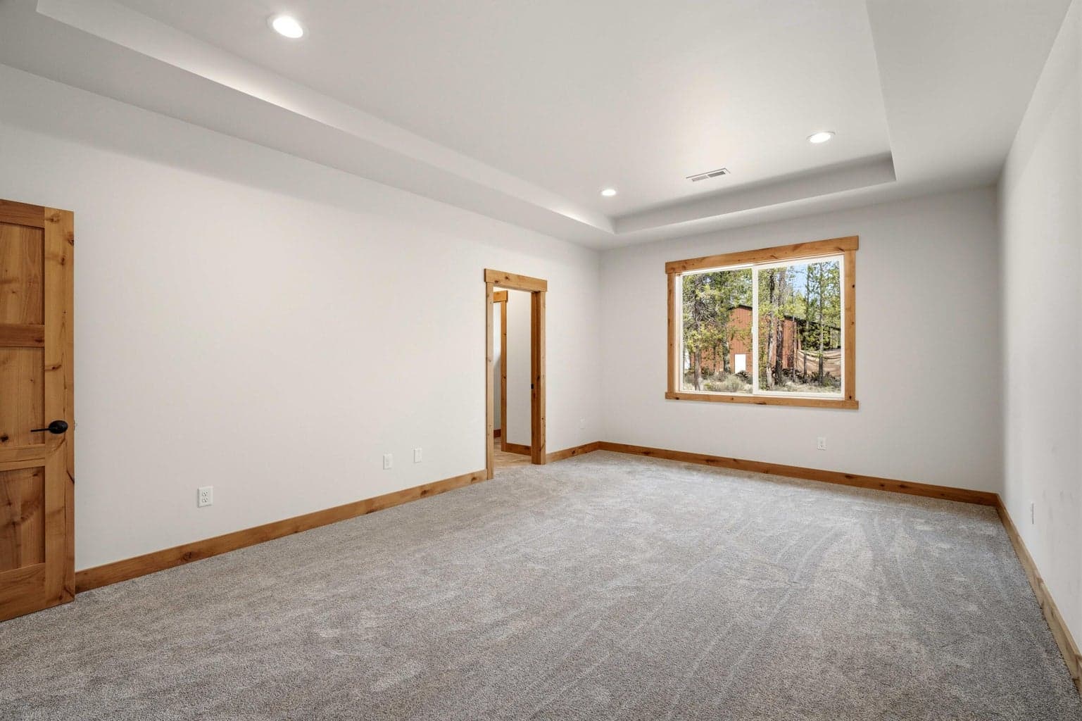 Generous primary bedroom offers a relaxing retreat with a bright window, soft finishes, and ample room to unwind.