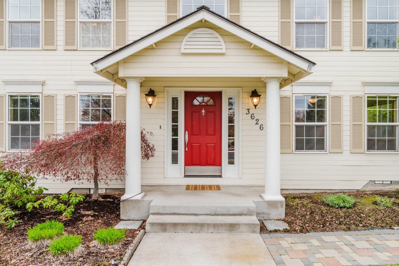 Classic entry pillars on the covered front porch of this inviting colonial style home in Cascade View Estates. You can see the beginning of this wonderful landscaped yard, with a paver walkway that wraps around to the backyard, a Japanese maple and a rhododendron.