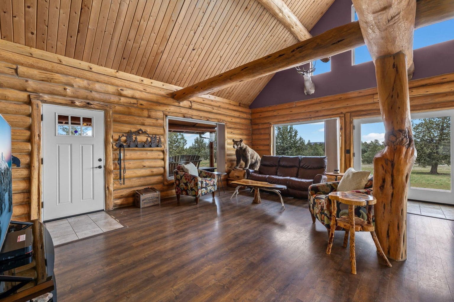 Open-concept great room with vaulted ceilings and large picturesque windows