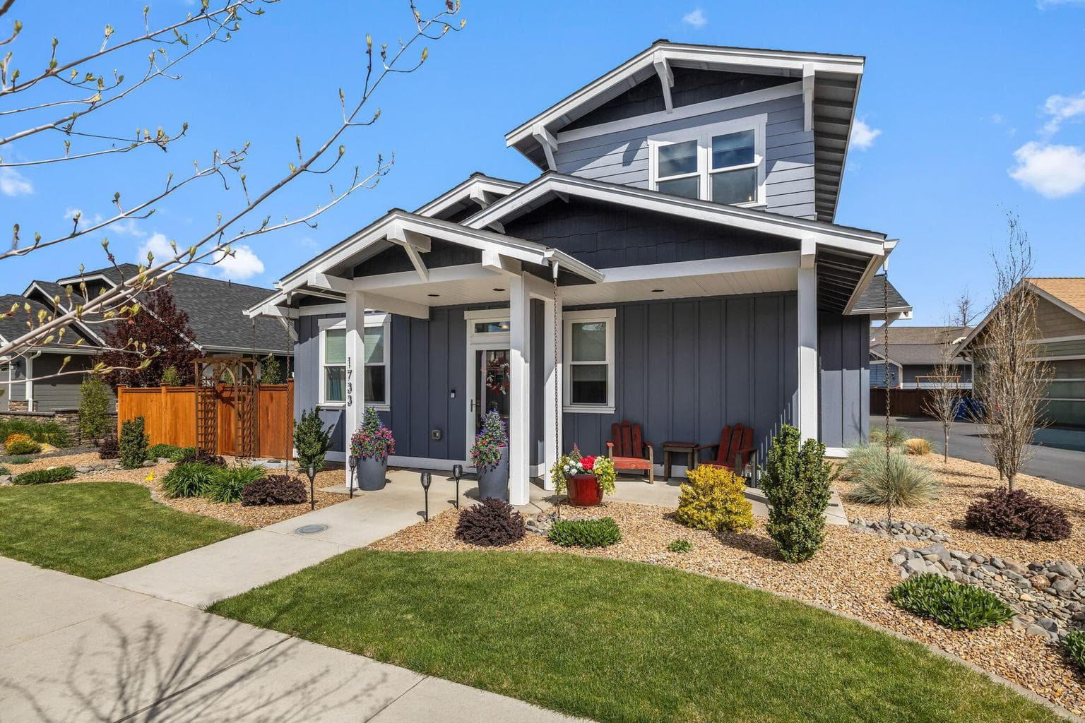 View of the covered front porch entry and professional landscaping.