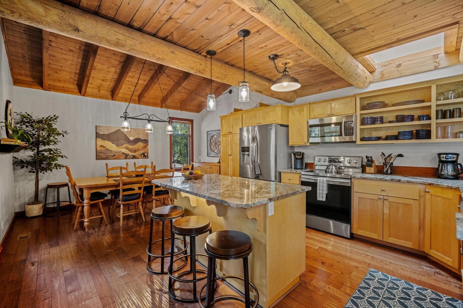 Updated open kitchen including granite surfaces, new cabinets, pantry and SS appliances