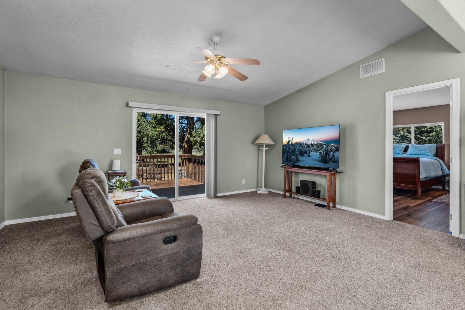 Living room with deck access, adjoins primary bedroom and kitchen area