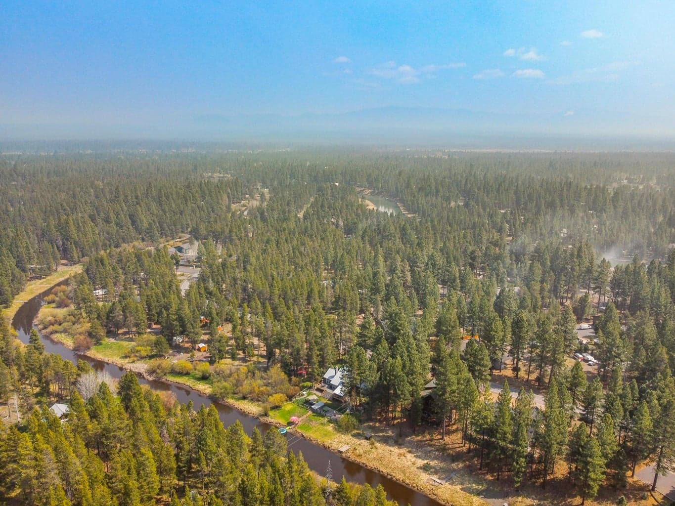 Aerial showing the chalet along the river bend within the Central Oregon forest