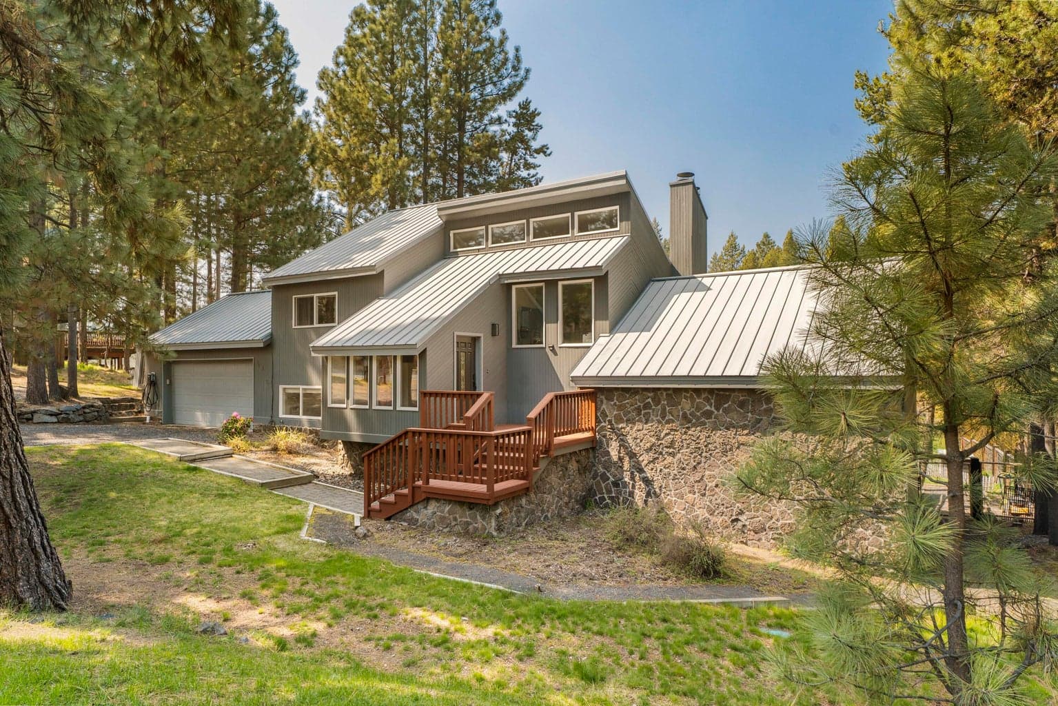 Contemporary chalet with stone foundation, standing-seam metal roof, and clerestory windows