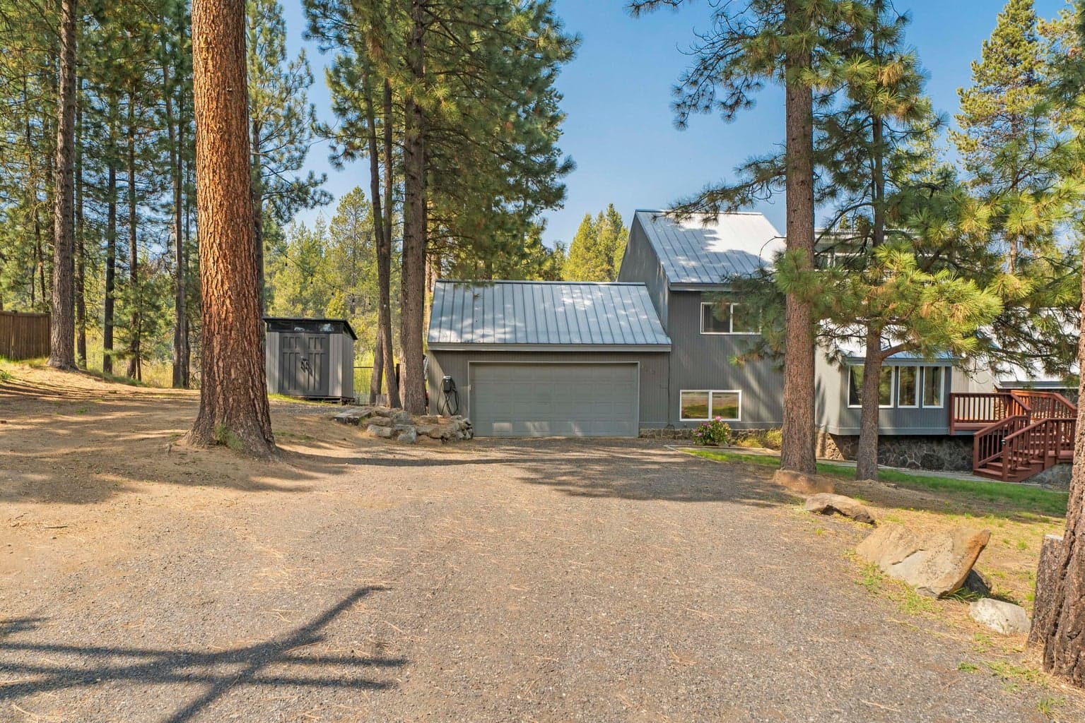 Detached two-car garage tucked into the ponderosa pines with EV charger