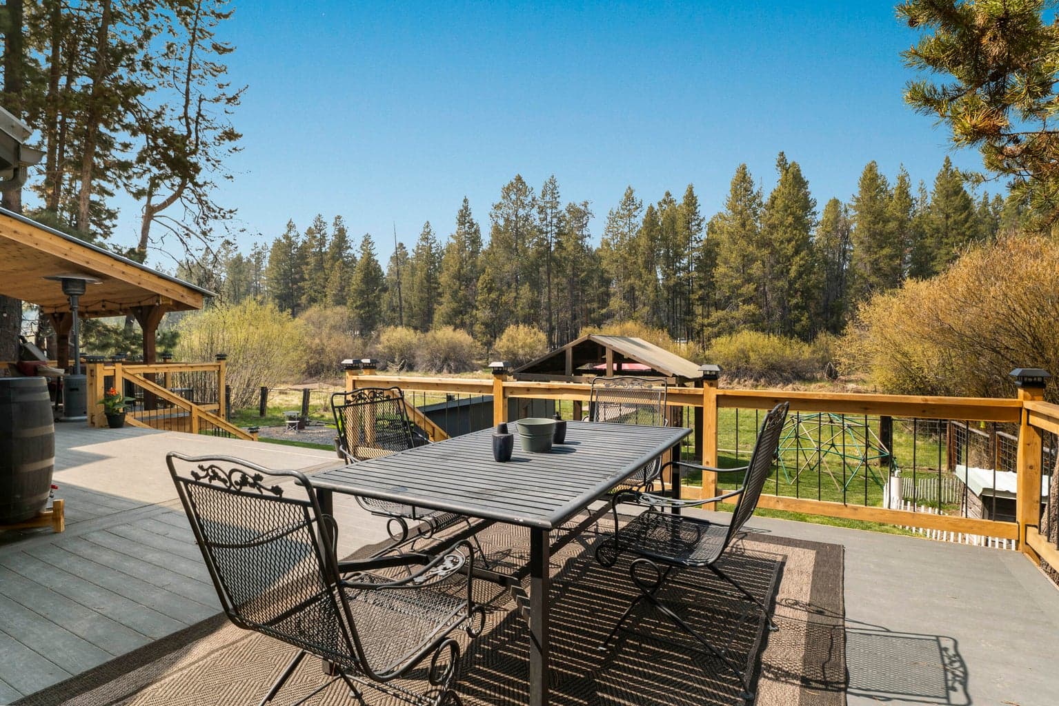 Wrought-iron dining set on the deck under towering ponderosa pines