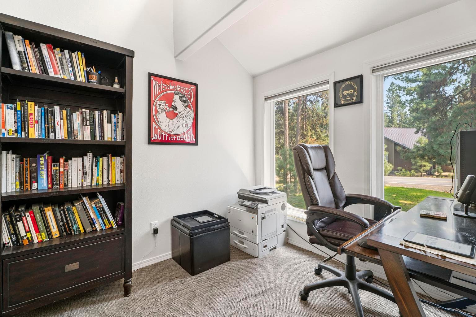 Library office nook with bookshelves and forest views from every window