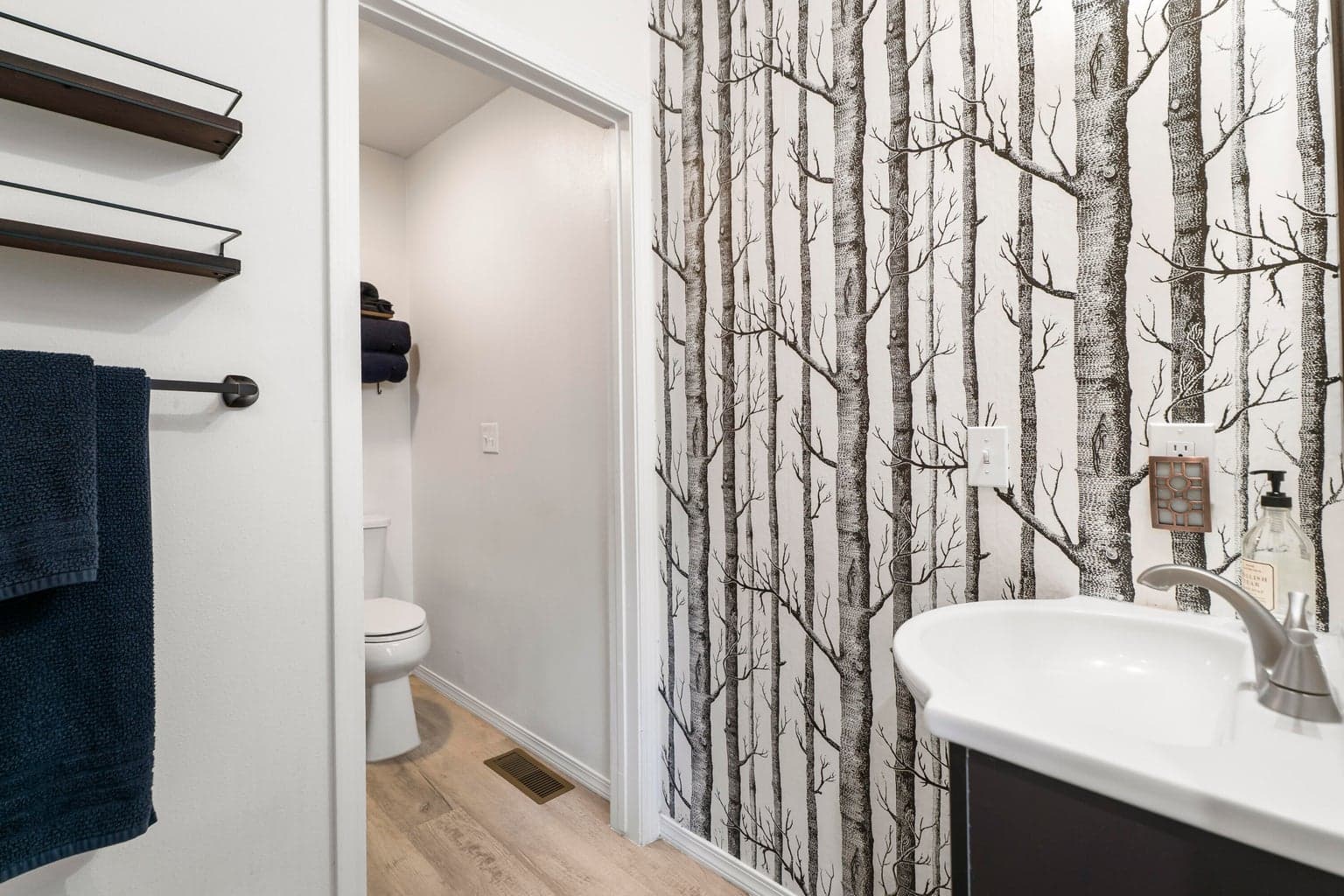 Upstairs bathroom with birch-forest wallpaper