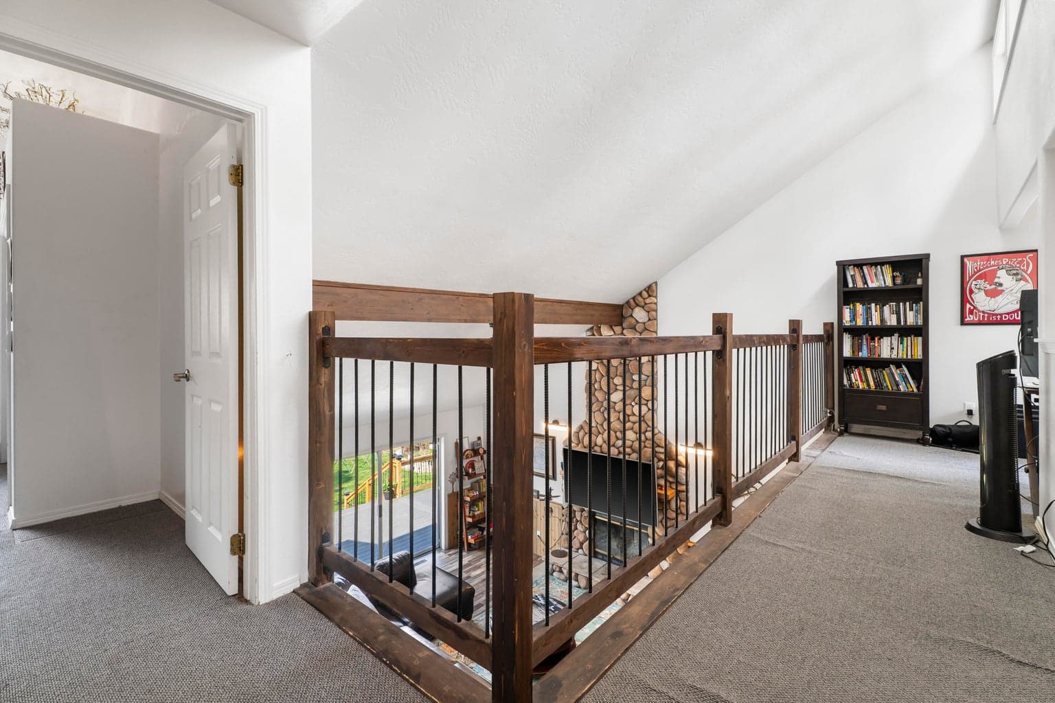 Loft landing with rebar-and-timber railing overlooks the great room below