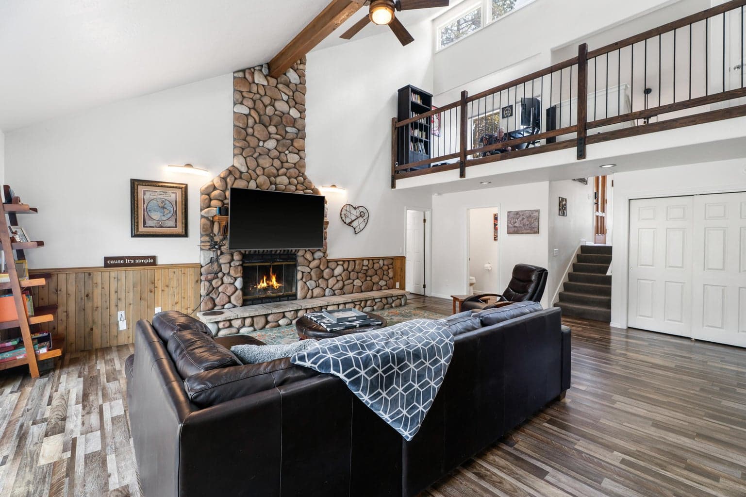 Two-story living room with mountain-cabin scale, exposed beams, and modern light