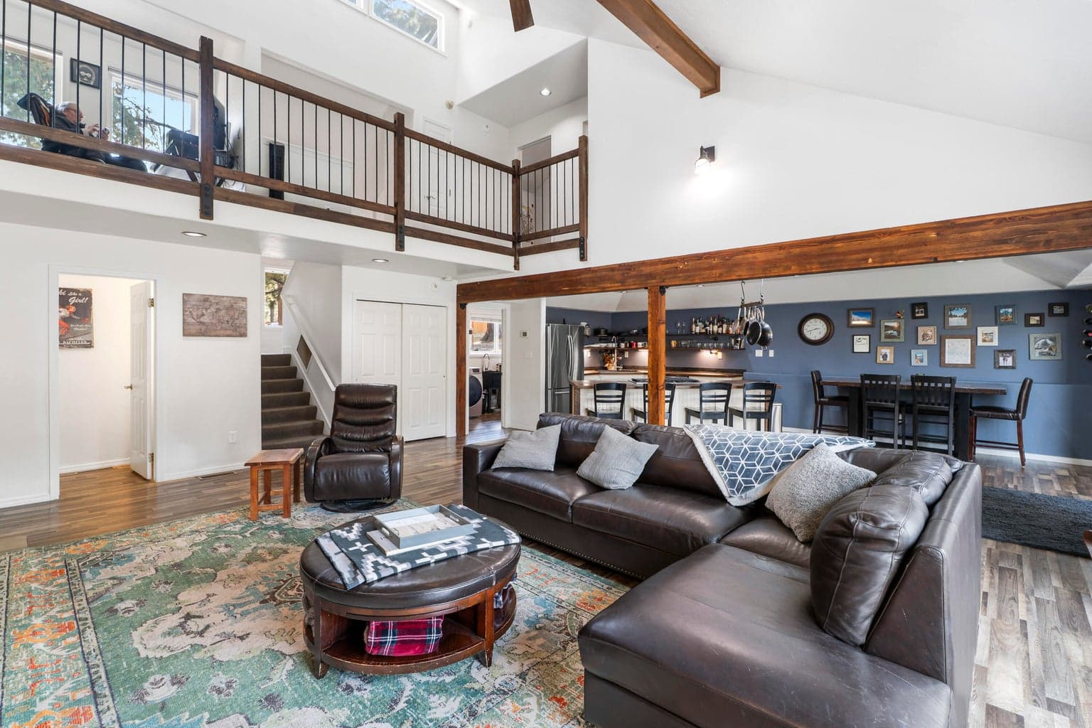 Open-concept living flows into kitchen, dining, and the loft above