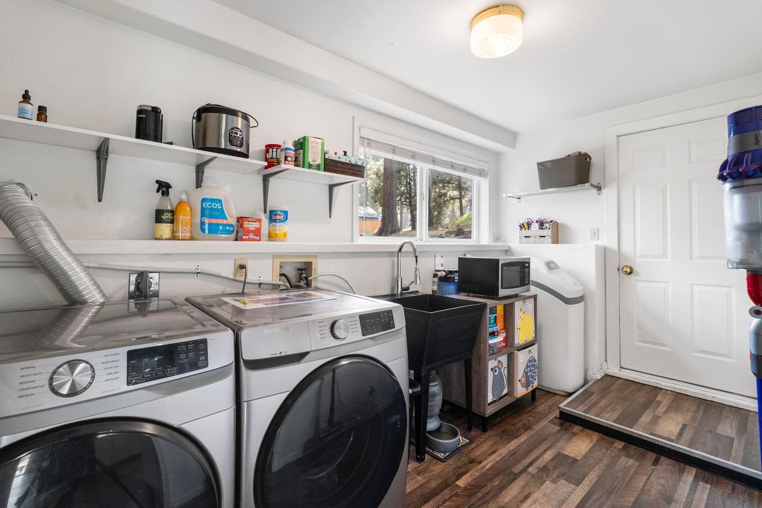 Spacious laundry room with utility sink, lots of storage and garage access
