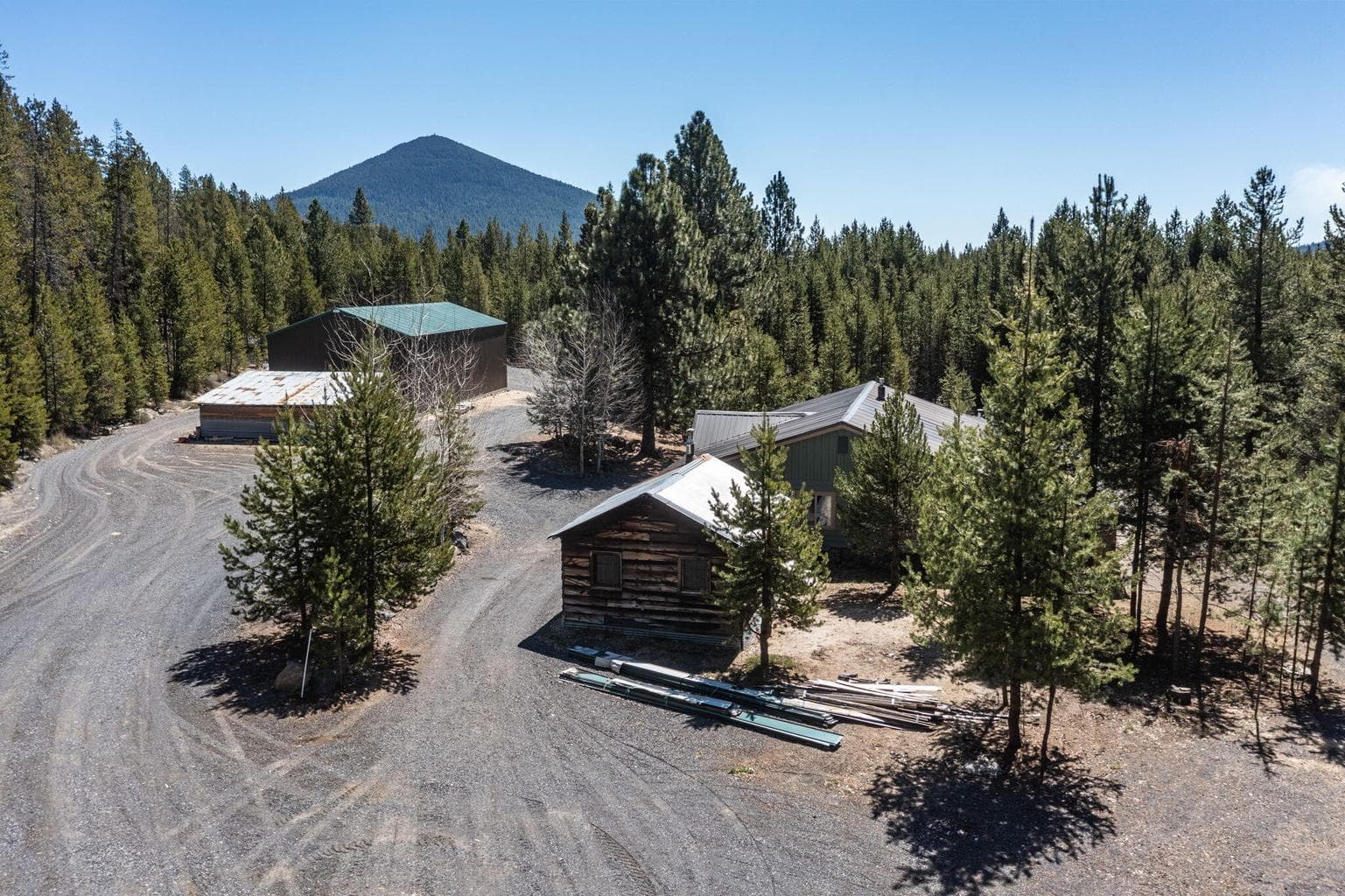 Wide shot of the yard showing the mature trees and secluded Cascade retreat setting.