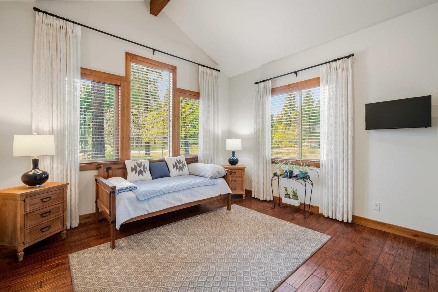 Second ensuite bedroom on main level of the home with lots of light and windows.