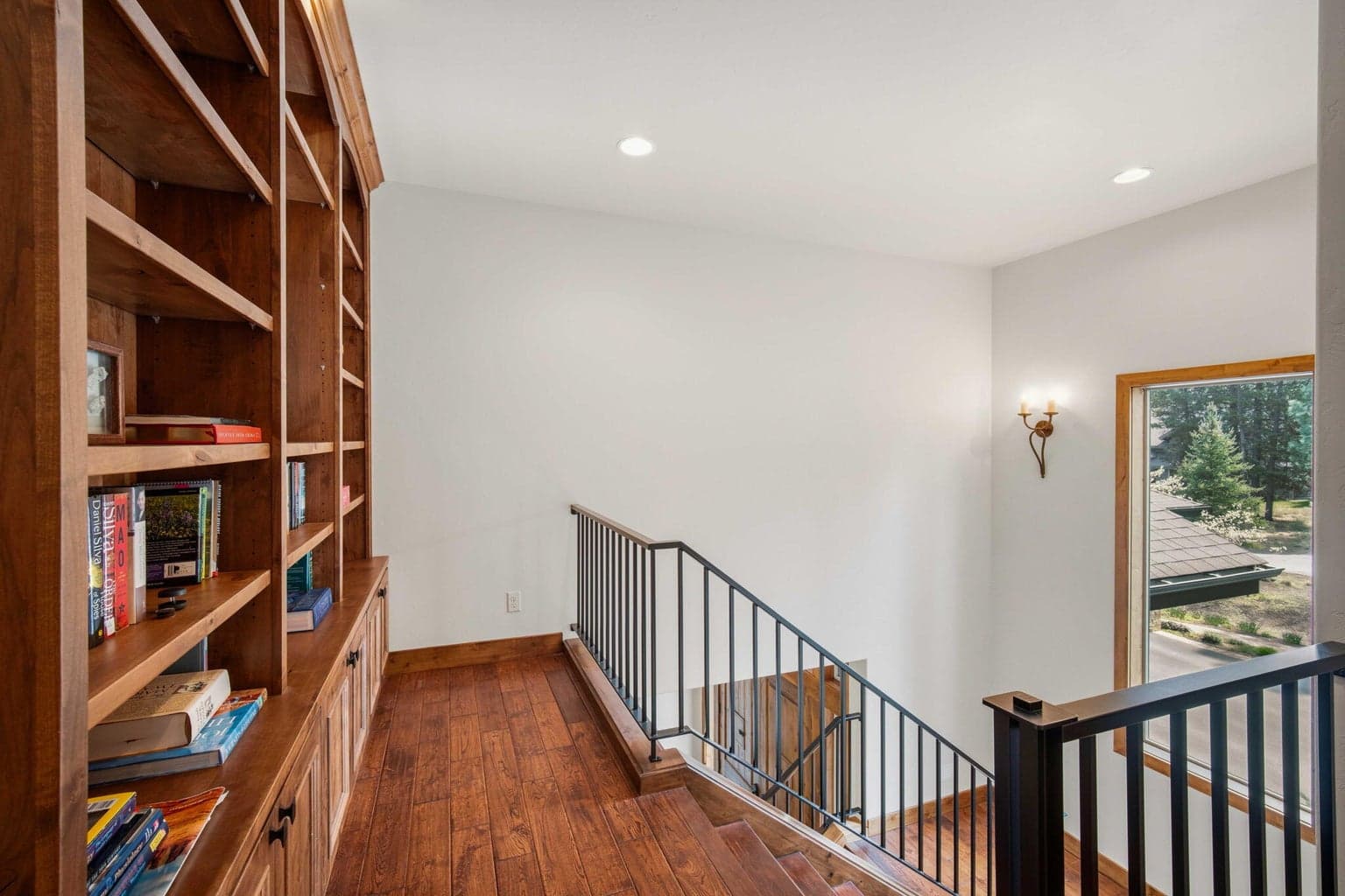 Custom bookshelves at the top of the stairs to the second level.