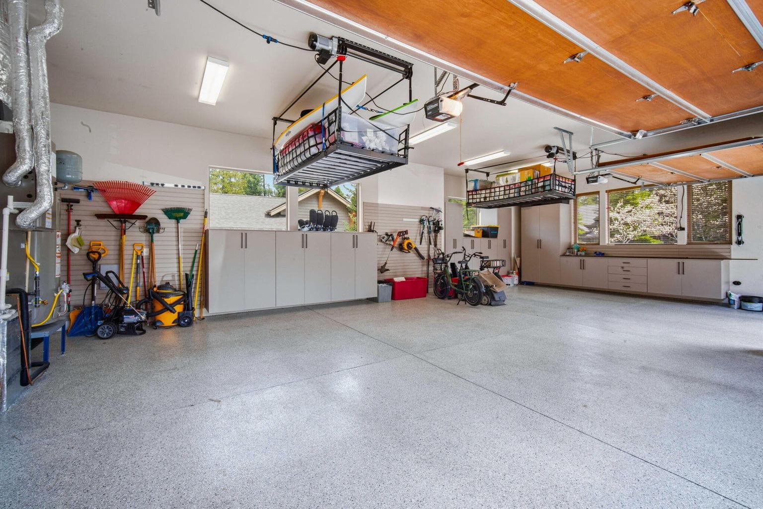 Oversized 3 car garage with epoxy flooring, custom cabinets and two electric lifts for storing your toys and seasonal items.