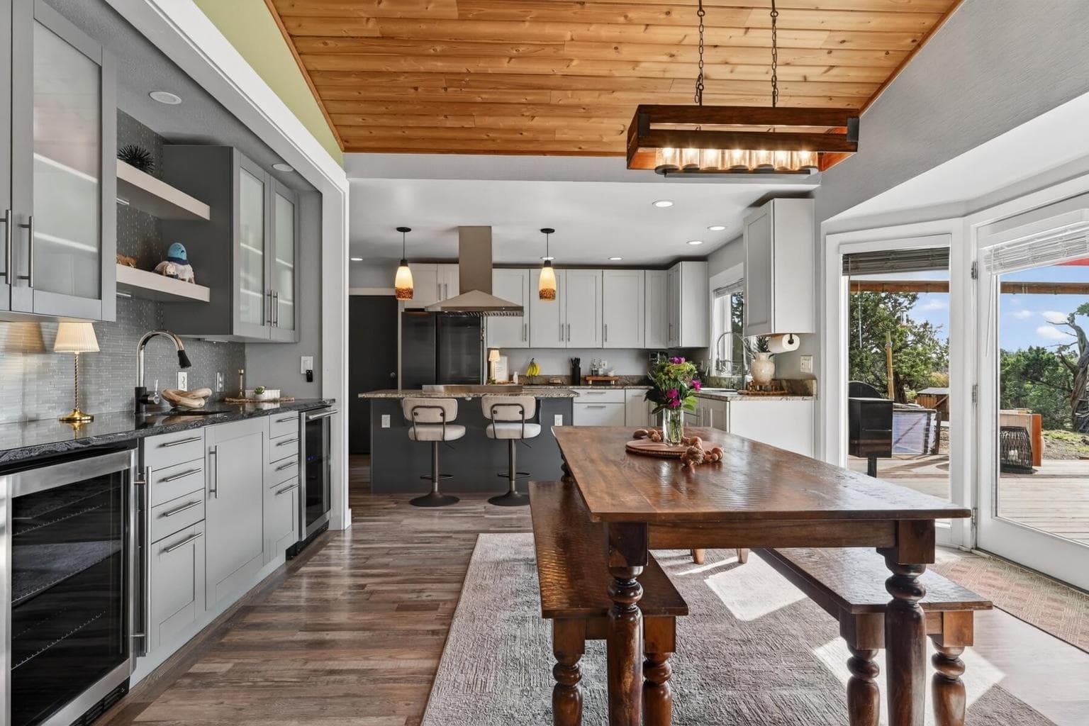 Updated modern kitchen with granite countertops, large center island, stainless steel appliances, and custom cabinetry. This Bend Oregon home features an open-concept kitchen with bar seating, pendant lighting, and abundant natural light—ideal for entertaining and everyday living.
