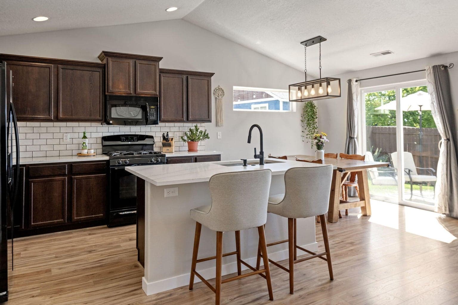 New Quartz countertops, subway tile backsplash, island seating & direct access to rear patio