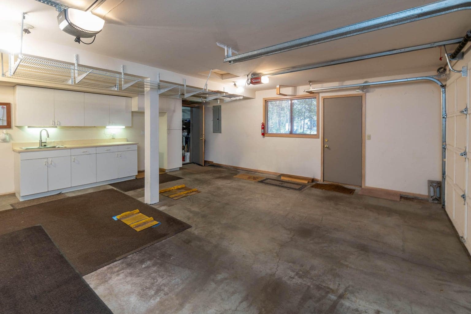 Oversized garage w/lots of room for your cars. There's a separate room to the right behind the window...could be your wine cellar or garage office Has lots of shelving to store gear too. Laundry/mud room is to the left of the lit workshop area/entrance to the house from the garage. Workshop area has its own sink. Heated garage area makes it comfortable to tinker even in colder weather.