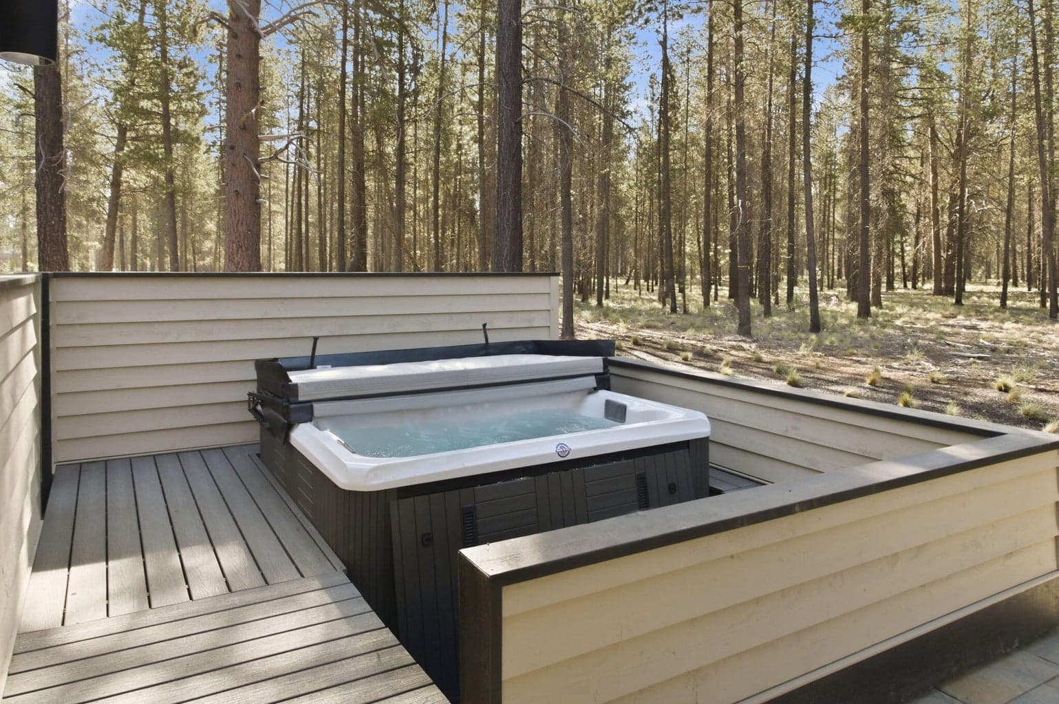 Stepped up Trex deck surrounds the recessed Woodstock 7-person LED lighted hot tub with a view into the nature preserve