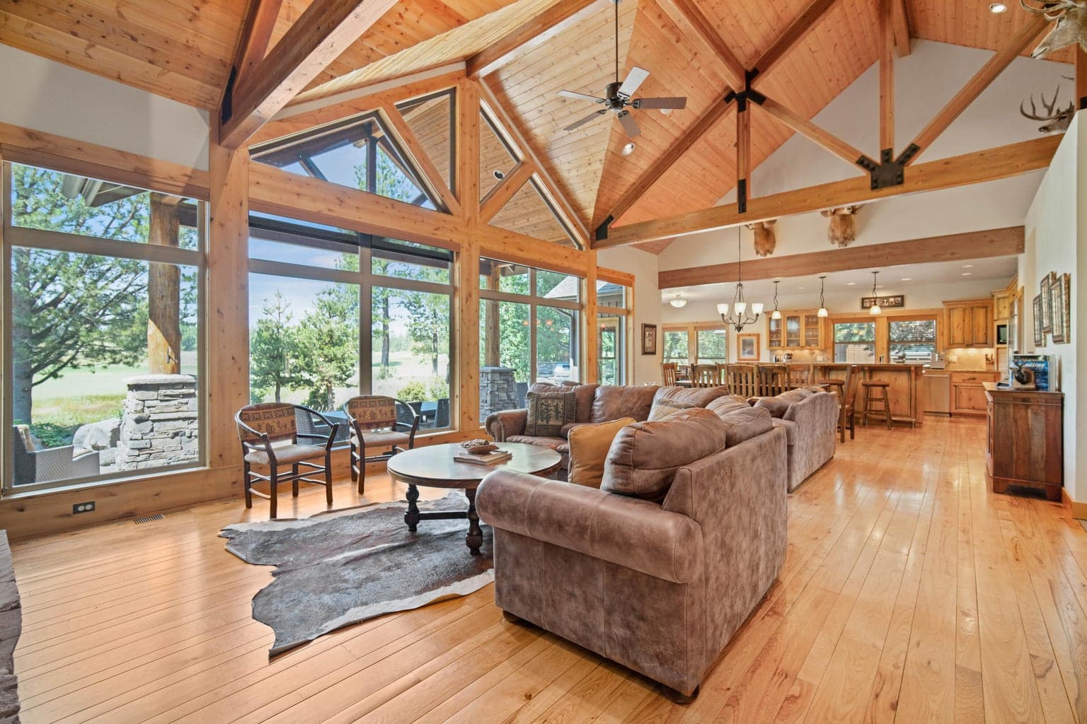 Great room with soaring wood ceilings, expansive windows, and views toward the outdoor living area and the Par 5 of the Caldera Springs Links golf setting.
