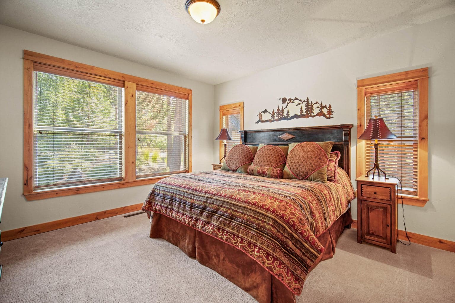 Main-level guest suite two with warm wood trim, large windows, and a comfortable suite-style feel.