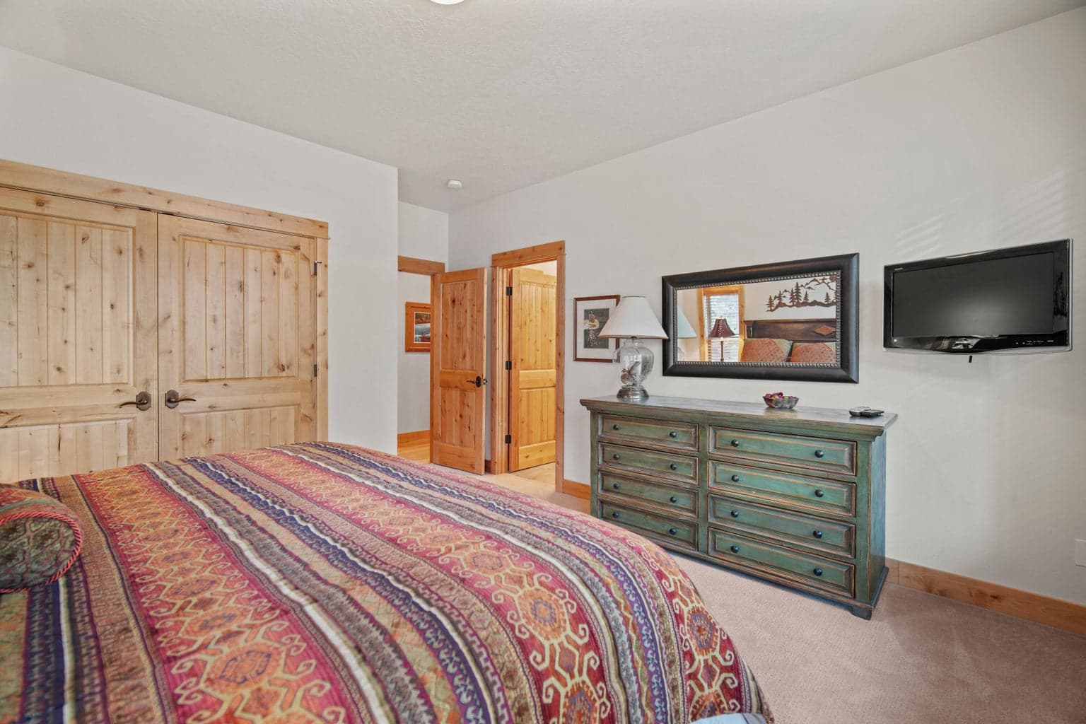 Guest suite with wood closet doors, seating area, and easy access to the en-suite bath.