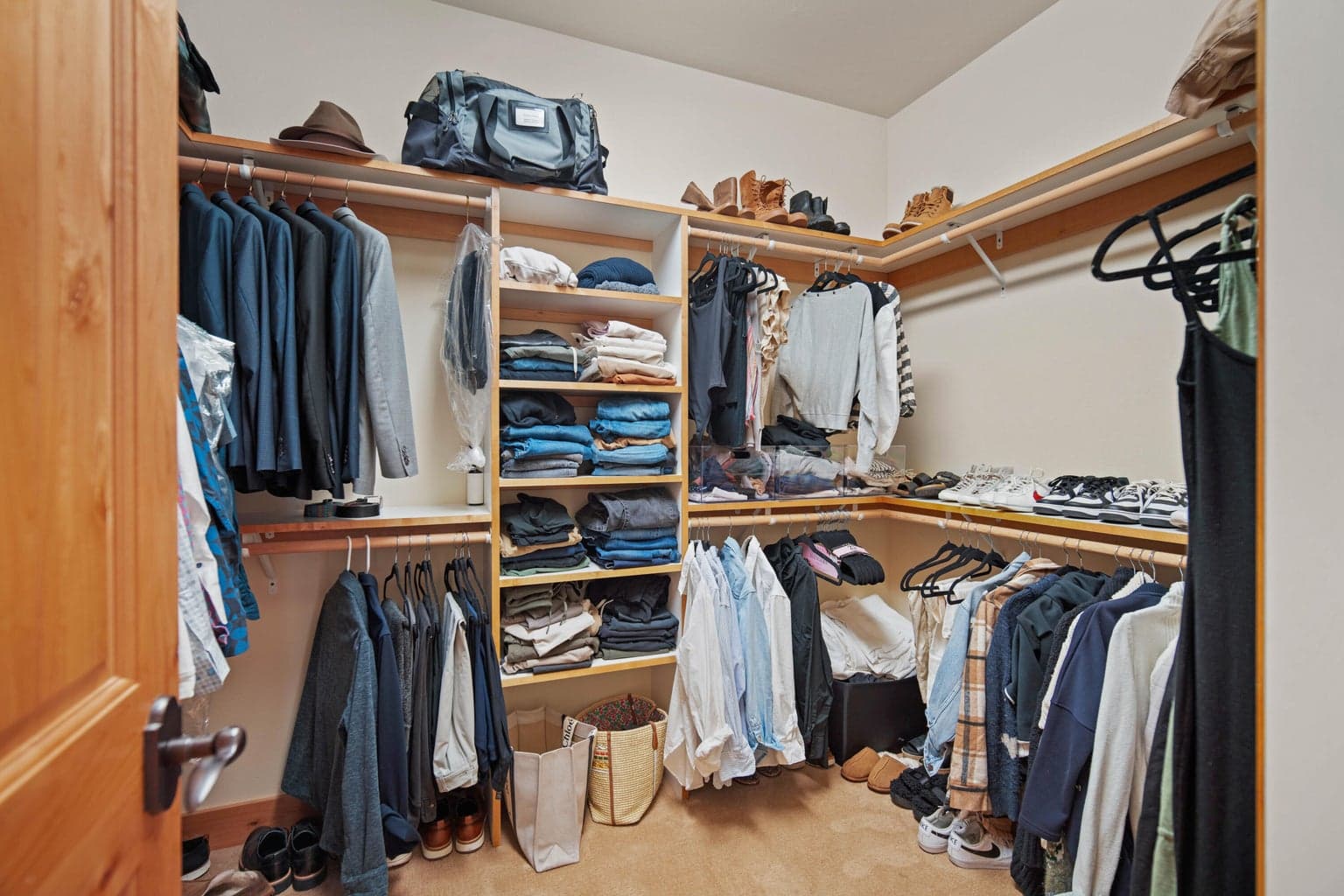 Organized walk-in closet with built-in shelving, hanging space, and practical storage.
