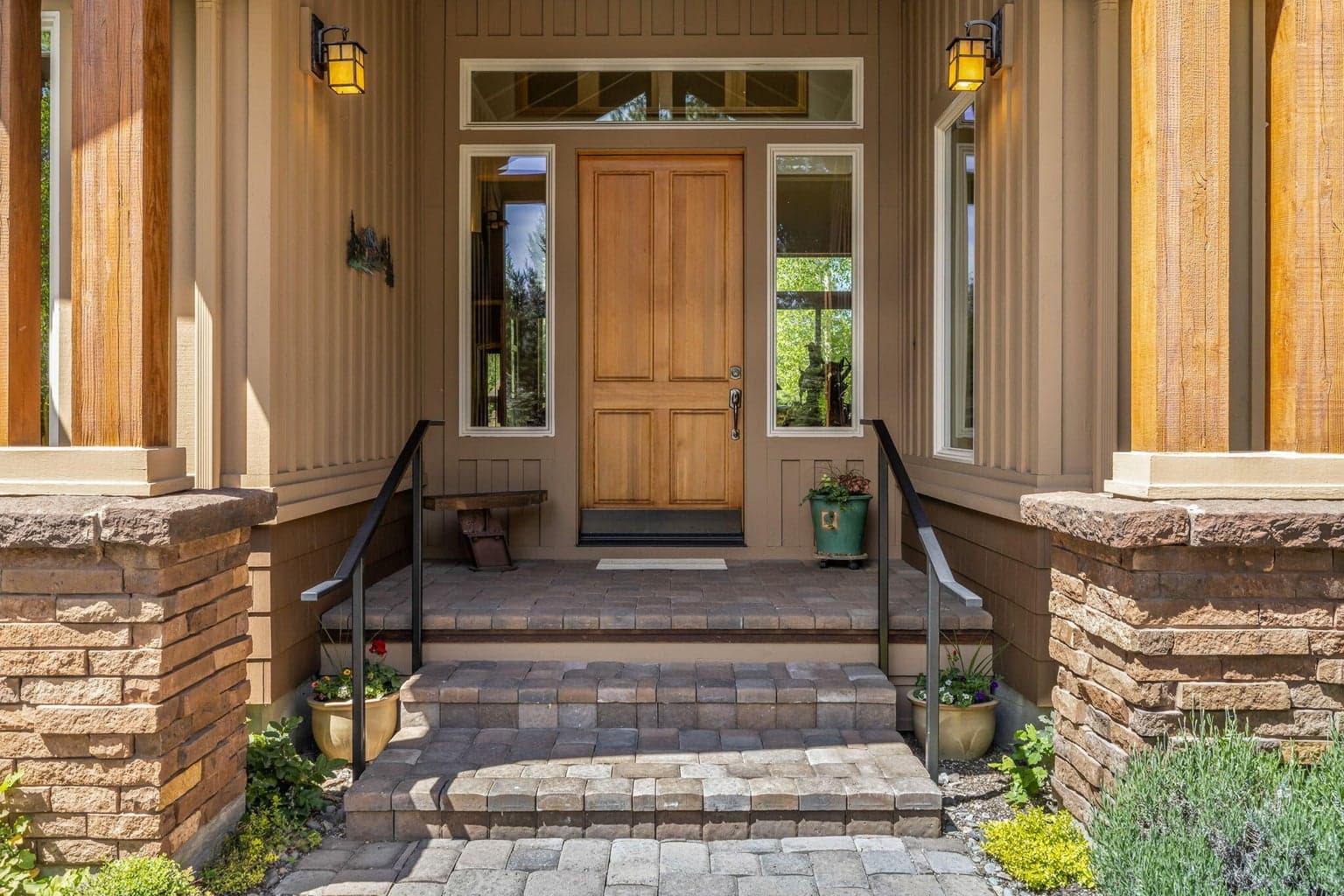 Covered front entry with timber accents, stone detailing, and a warm, inviting sense of arrival.