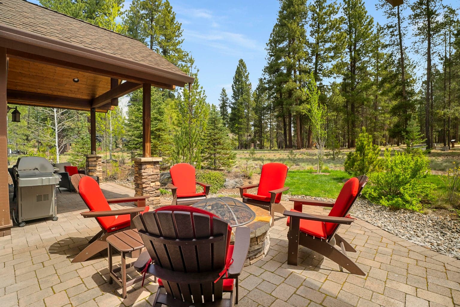 Relax and unwind on the covered paver patio complete with a firepit seating area, hot tub and peaceful wooded views.