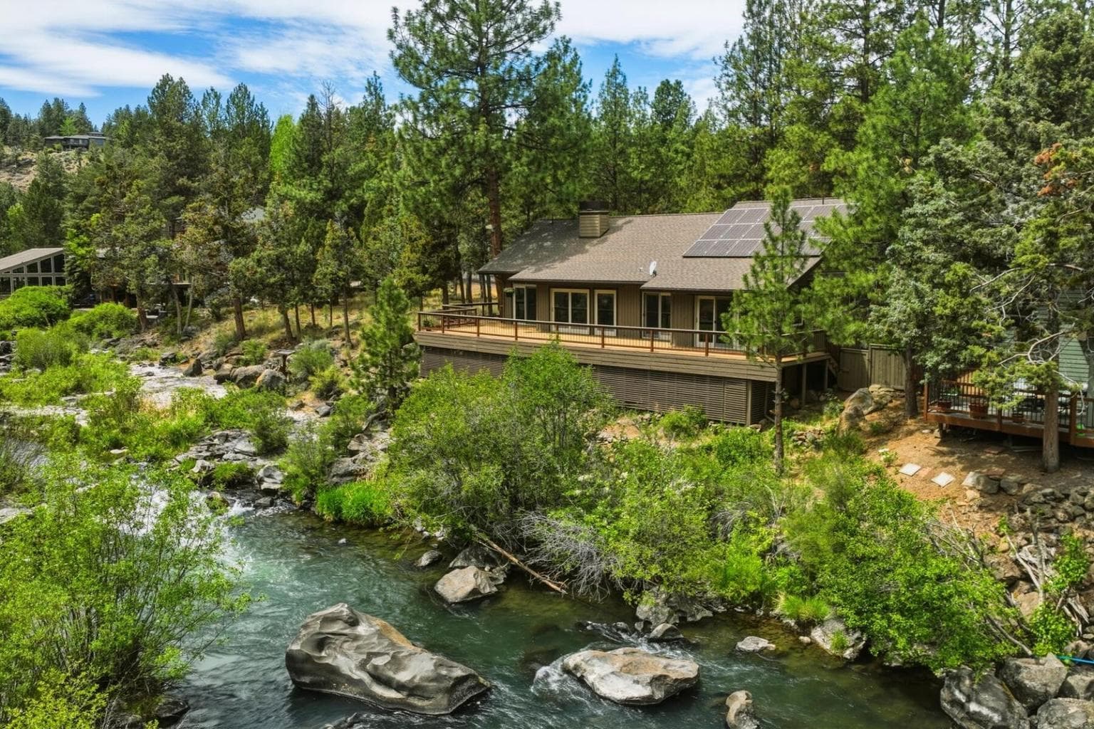 Small rapids in front of the home create a soundtrack to the Deschutes.