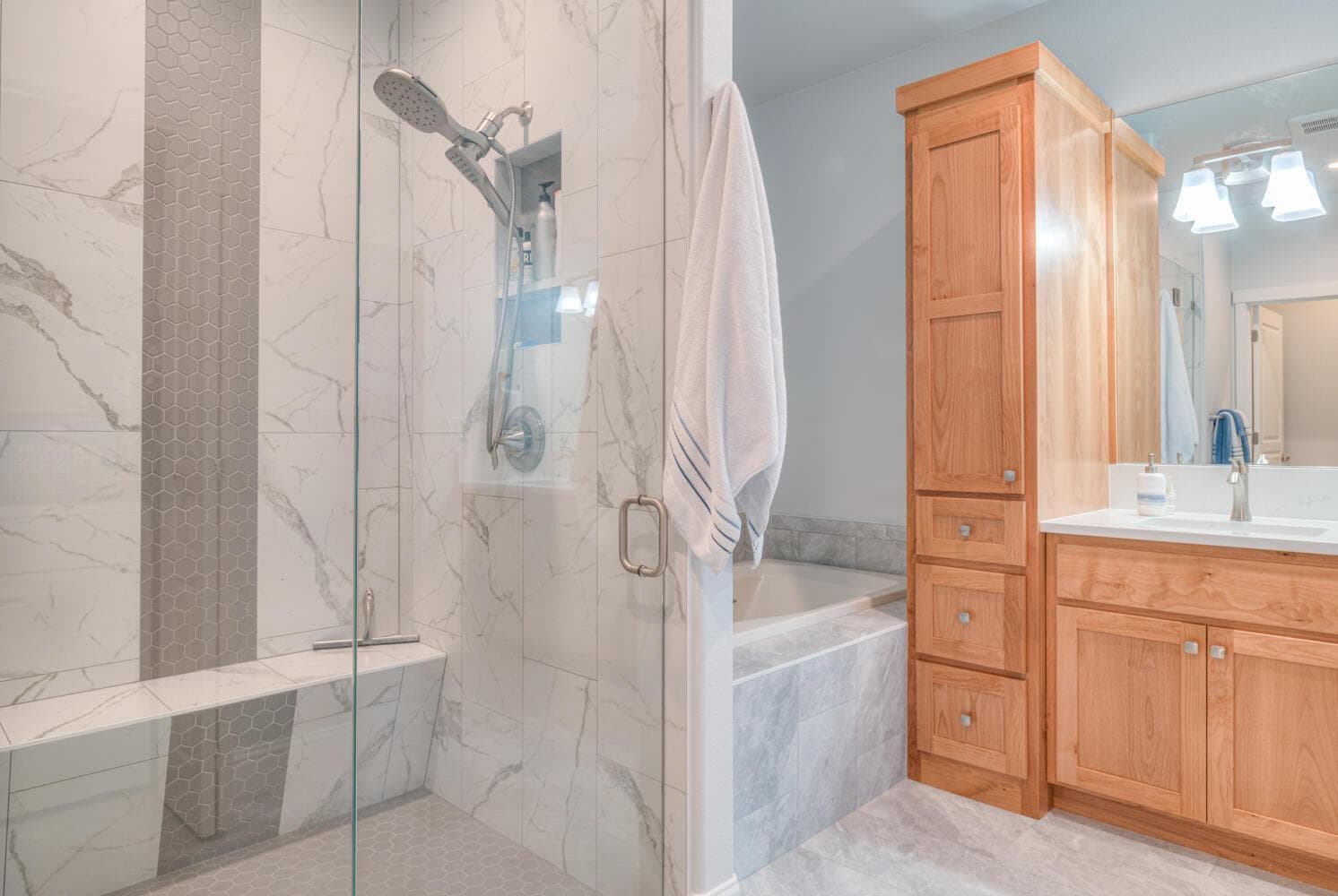 Enlarged tiled shower with built-in seat.