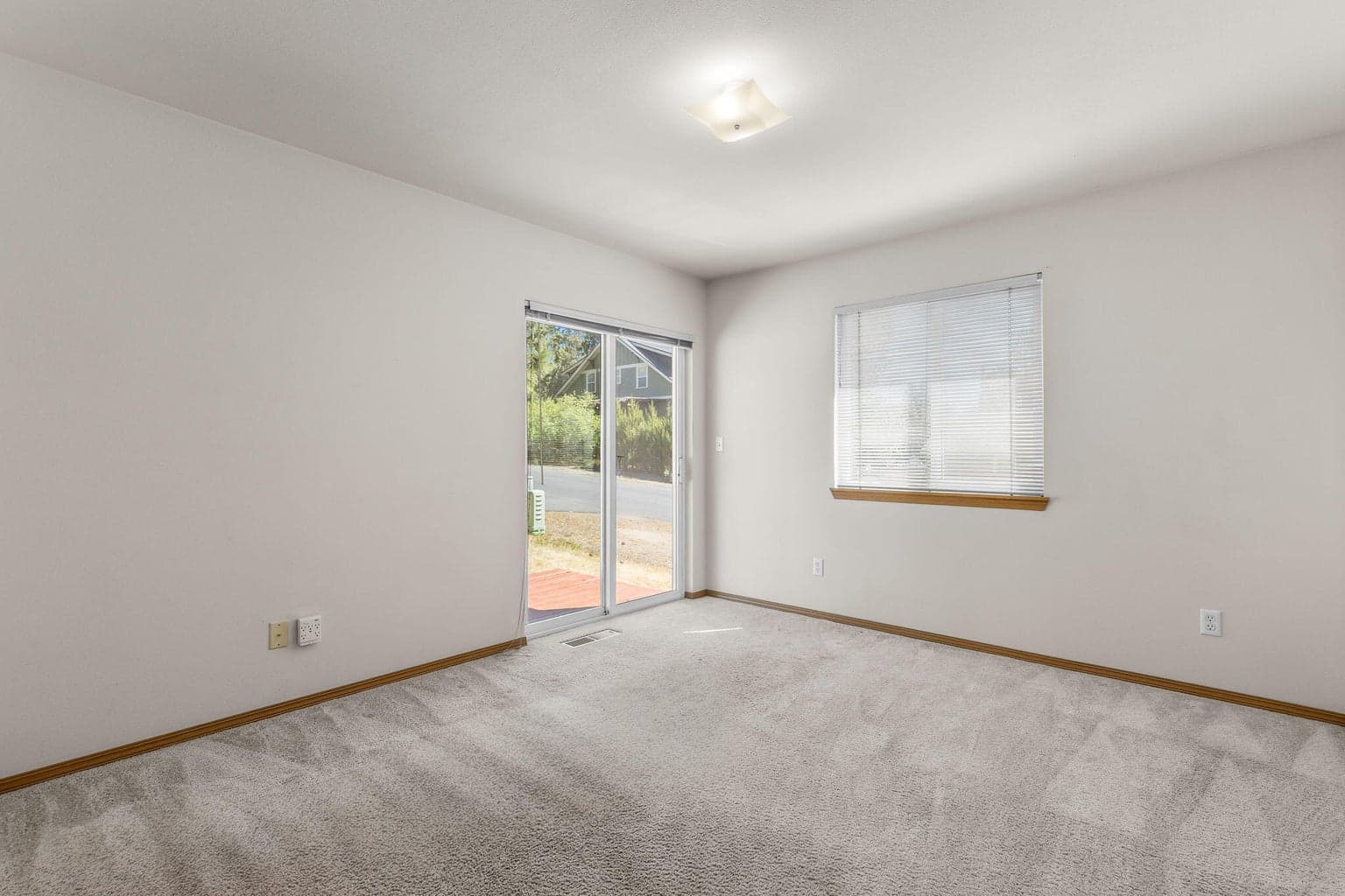 Comfortable primary suite offering privacy & natural light w/sliding doors to back deck.