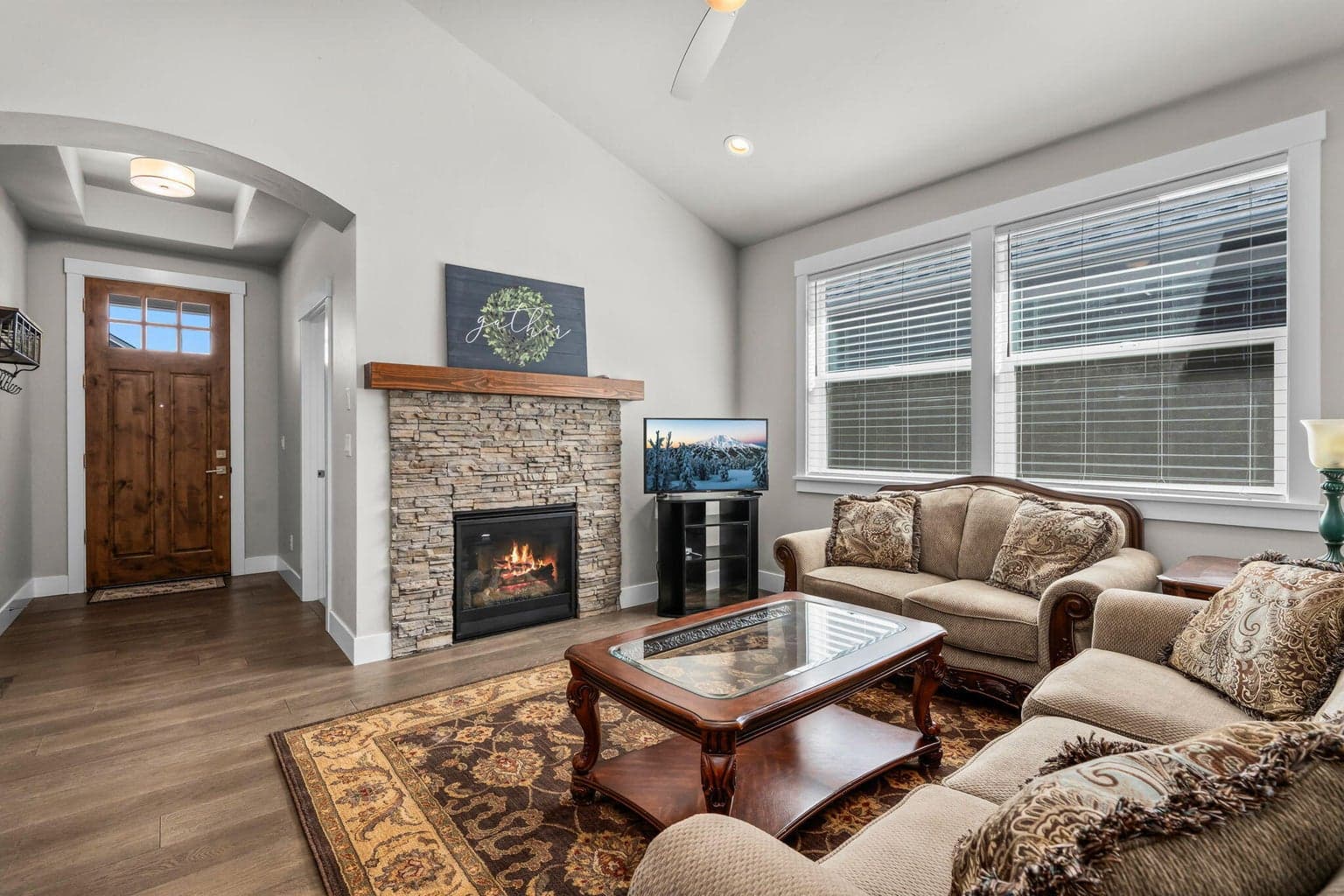 Cozy stacked stone fireplace anchors the open living space