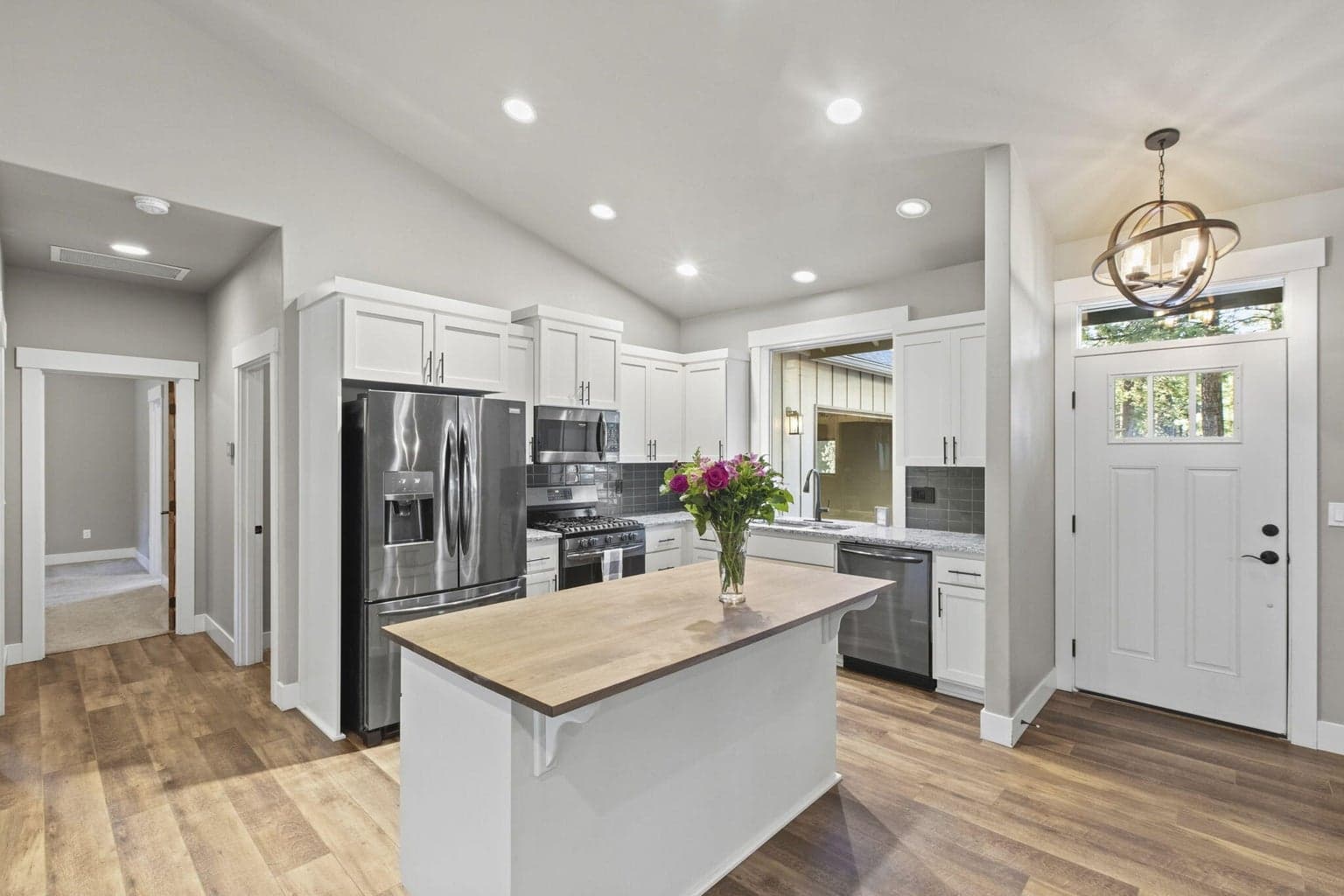 Kitchen with walnut butcher block island and black stainless appliances.