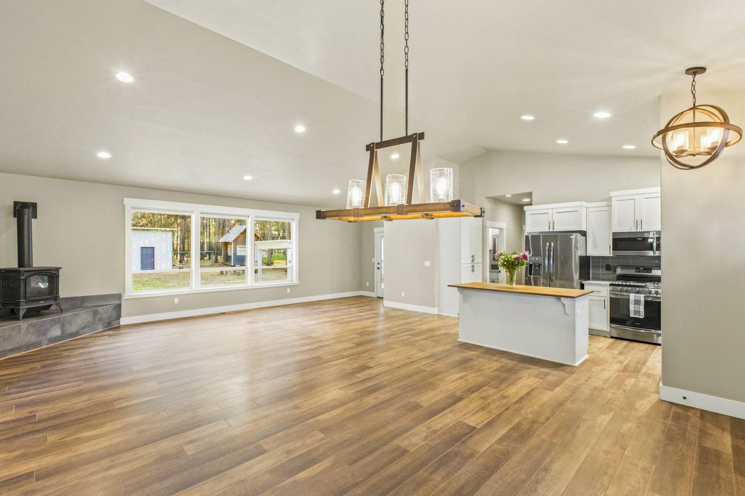 Great room with propane fireplace and large backyard-facing windows.