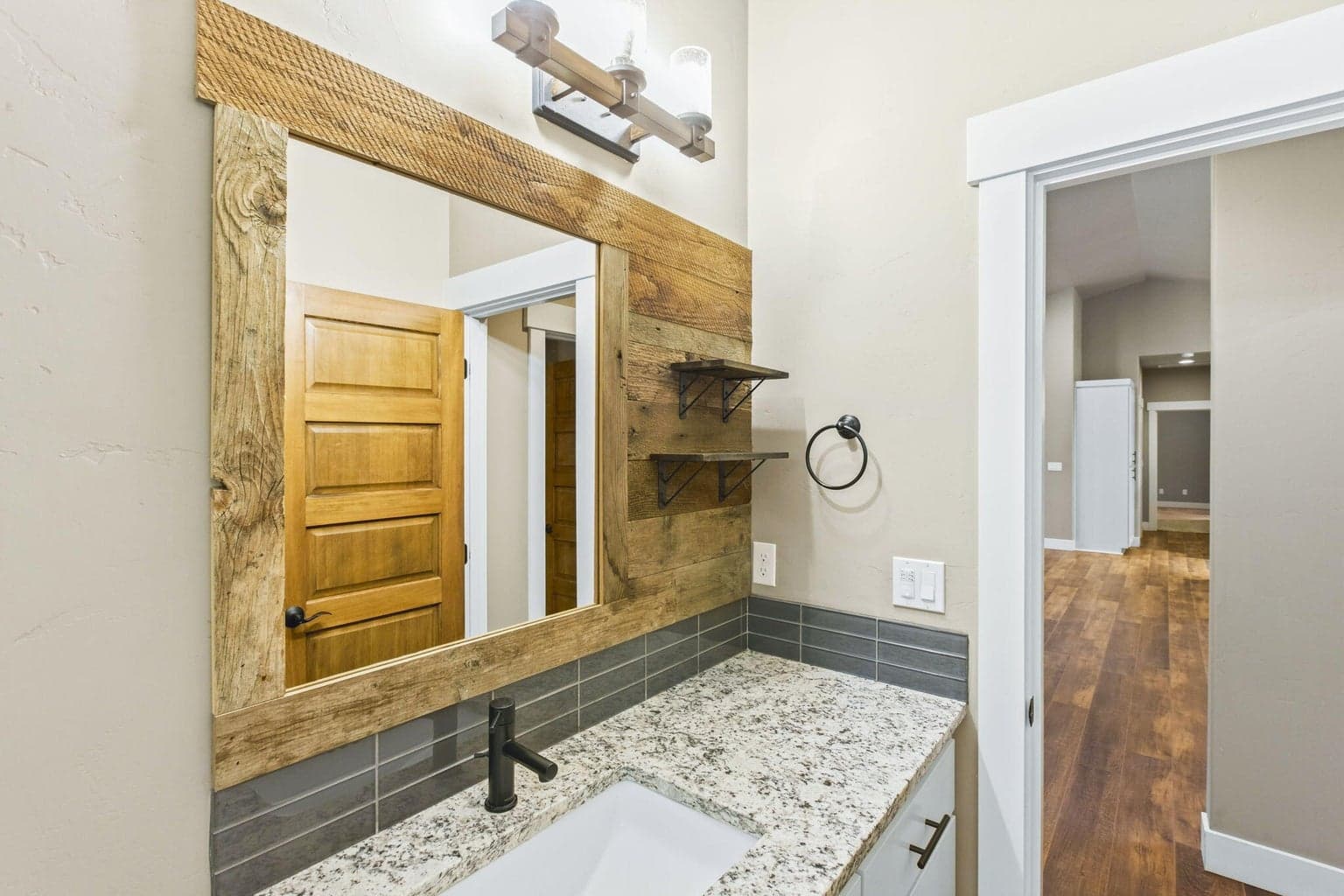 Stylish guest bath featuring granite counters and custom wood accents.