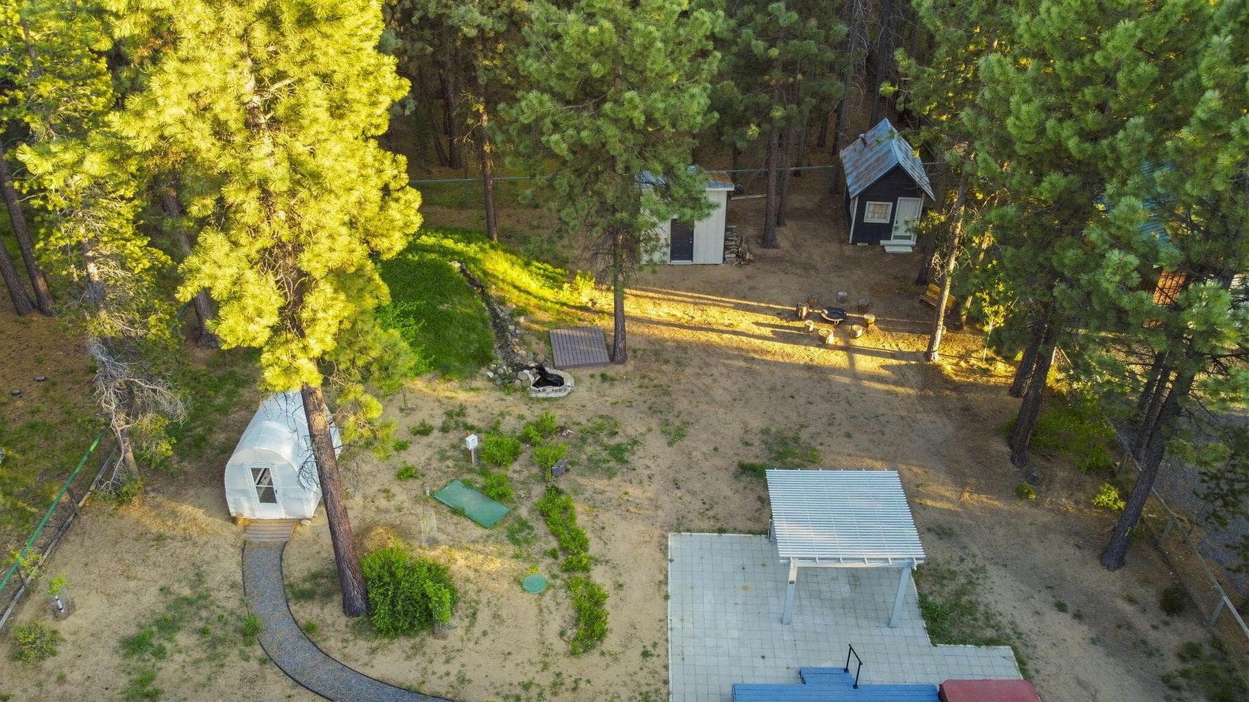 Backyard features include greenhouse, firepit, pergola, and outdoor living spaces.