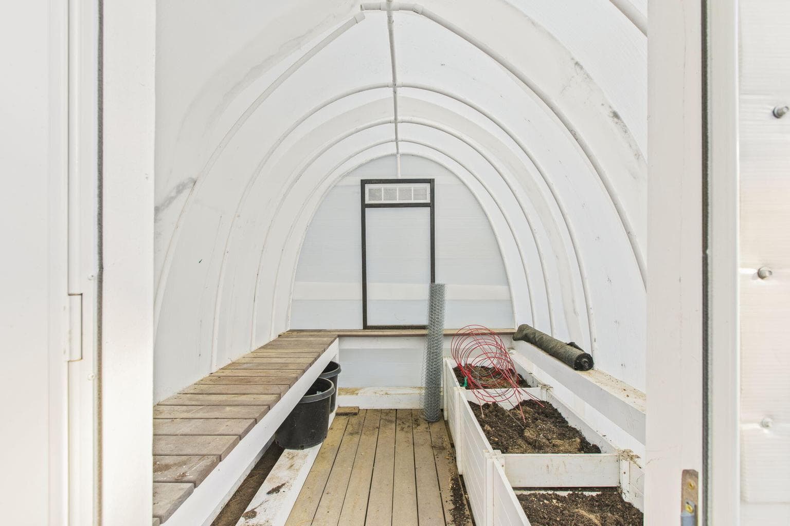 Greenhouse interior, year-round gardening, raised planting beds, hobby gardening, sustainable living.