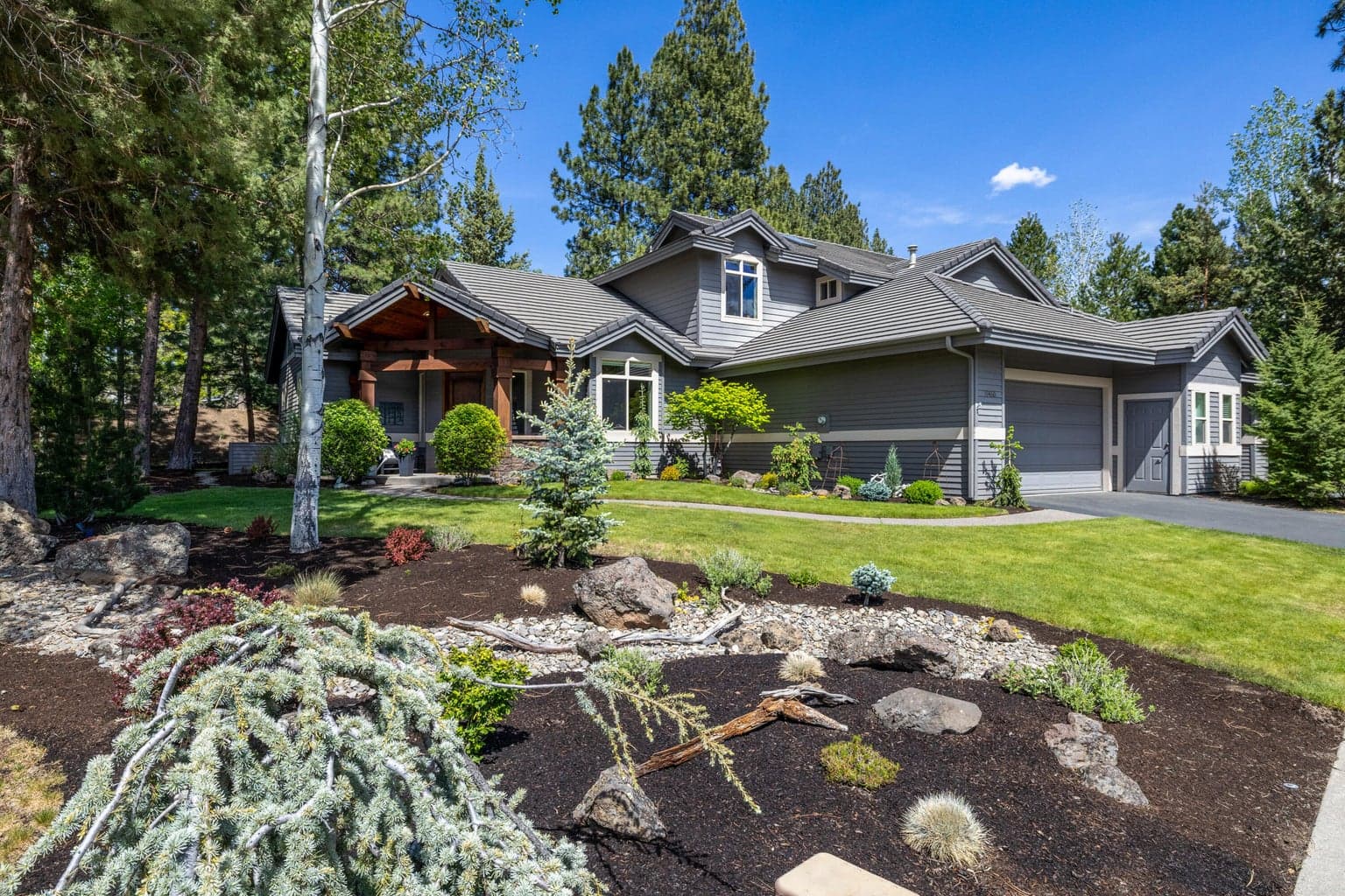 Beautifully remodeled Tyrion Sky townhome in Broken Top, framed by mature landscaping, paver-style paths and a welcoming covered entry.