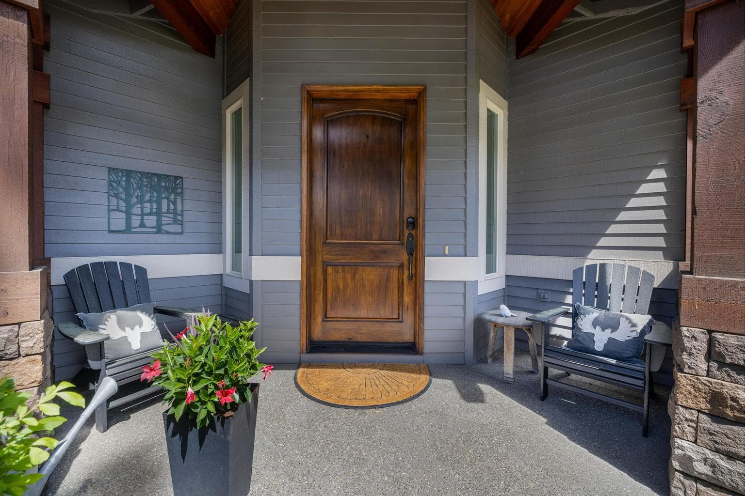 A covered front entry creates an inviting arrival, with rich wood detailing, updated exterior finishes and space to pause before stepping inside.