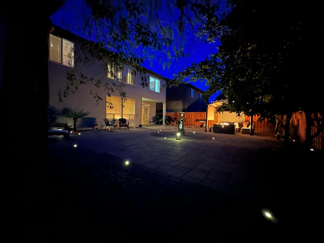 Twilight Completely hardscape back yard with in ground lighting, built in gas fireplace, and elegant water feature.