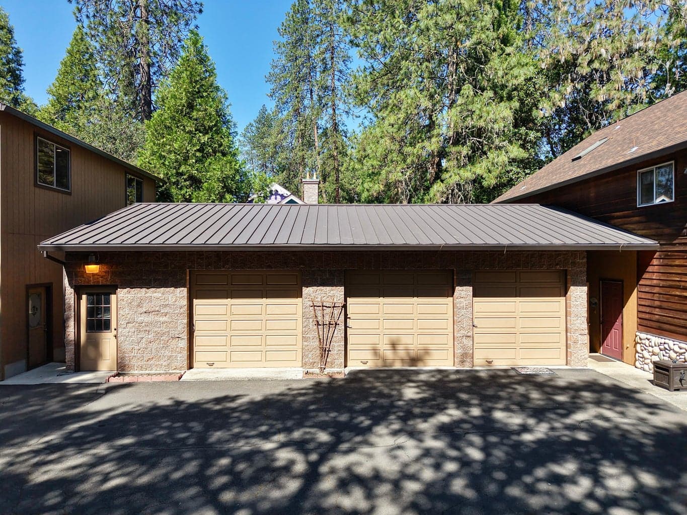 3 car garage nestled between house on R. and large Garage on left.