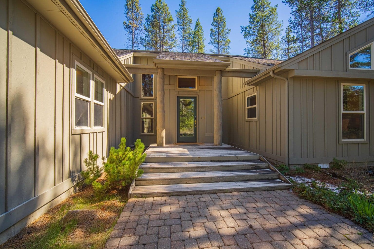 Covered front entry with paver approach, wood accents, and a welcoming Sunriver resort-home feel.