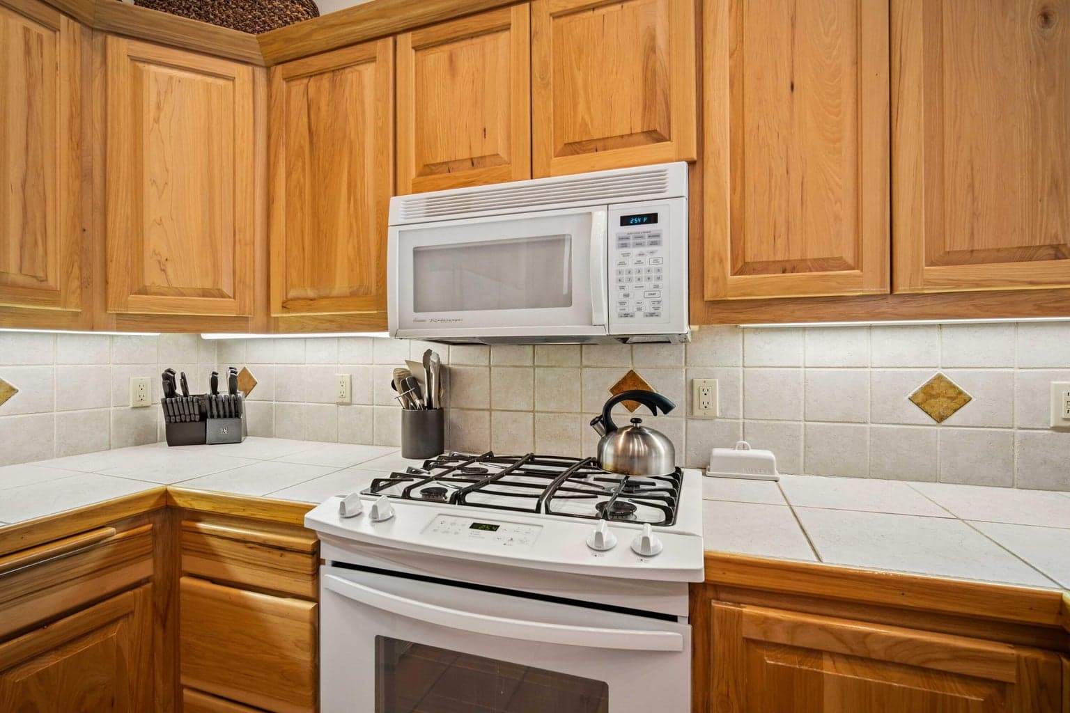 Gas range and tile backsplash detail in the kitchen of this Sunriver, Oregon resort-area home.
