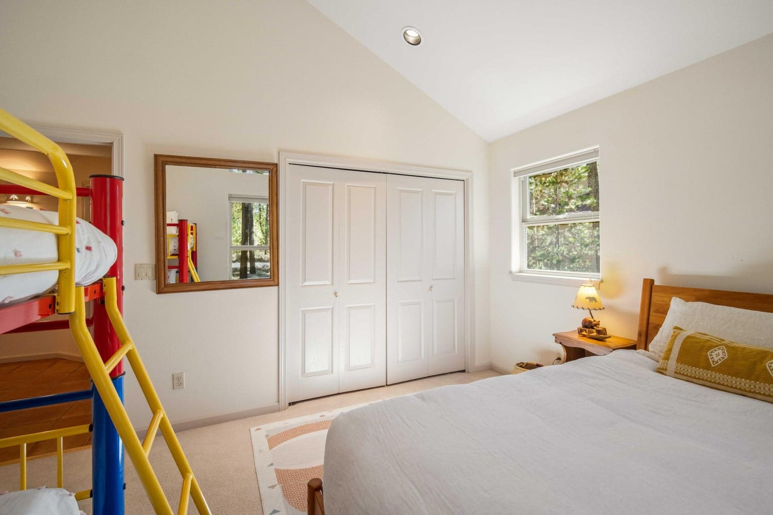 Bunk room view with closet access, treed windows, and a flexible layout for guests or vacation-home use.