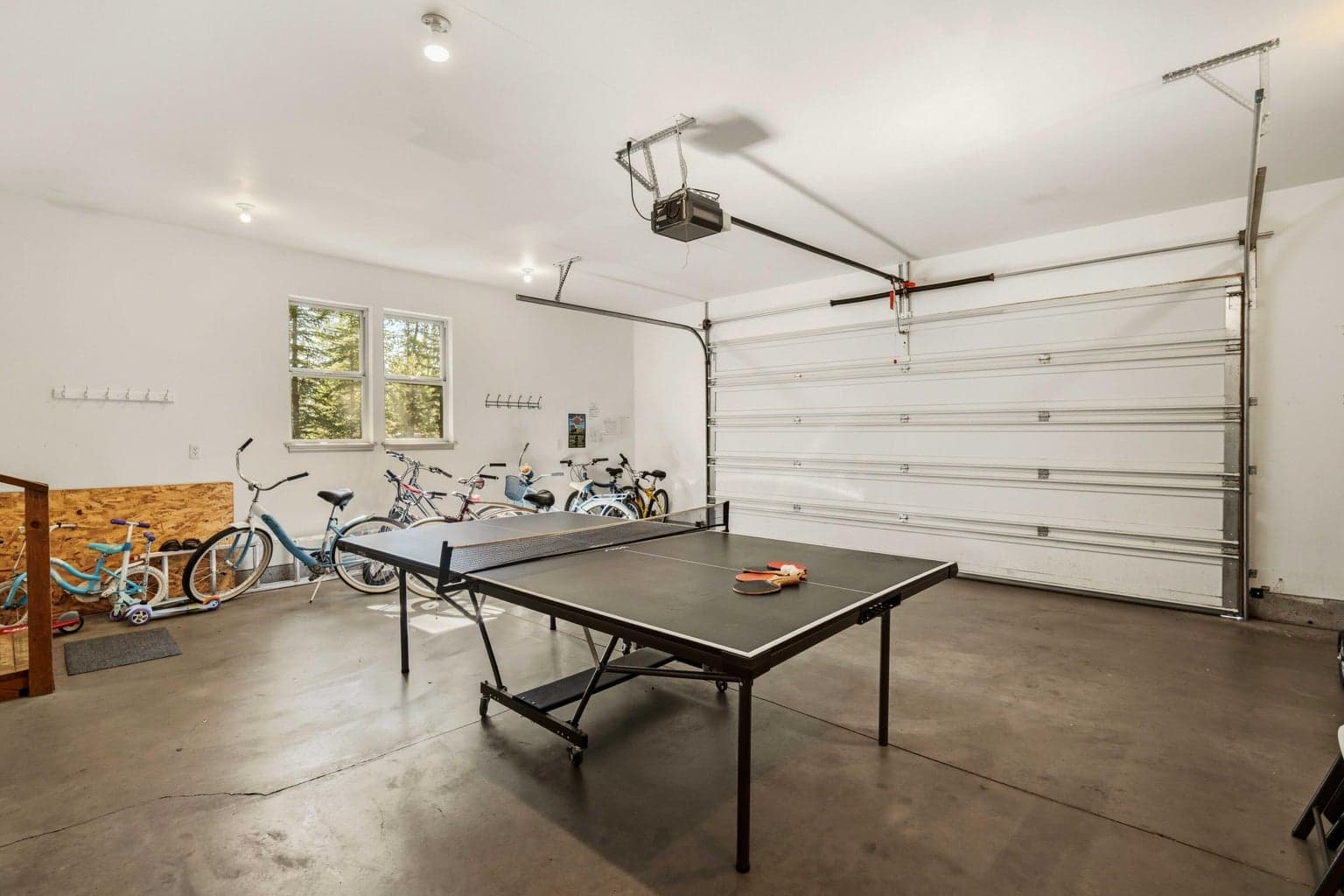 Garage view with bike storage and open floor area, useful for Sunriver bikes, river gear, skis, and outdoor equipment.