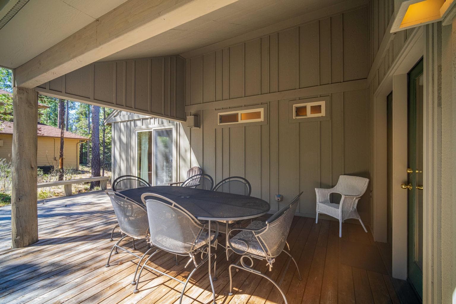 Covered outdoor dining deck with room to gather, relax, and enjoy the Sunriver pine setting.